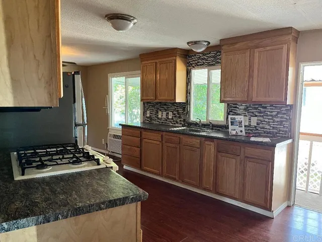 a kitchen with wooden cabinets and a stove top oven