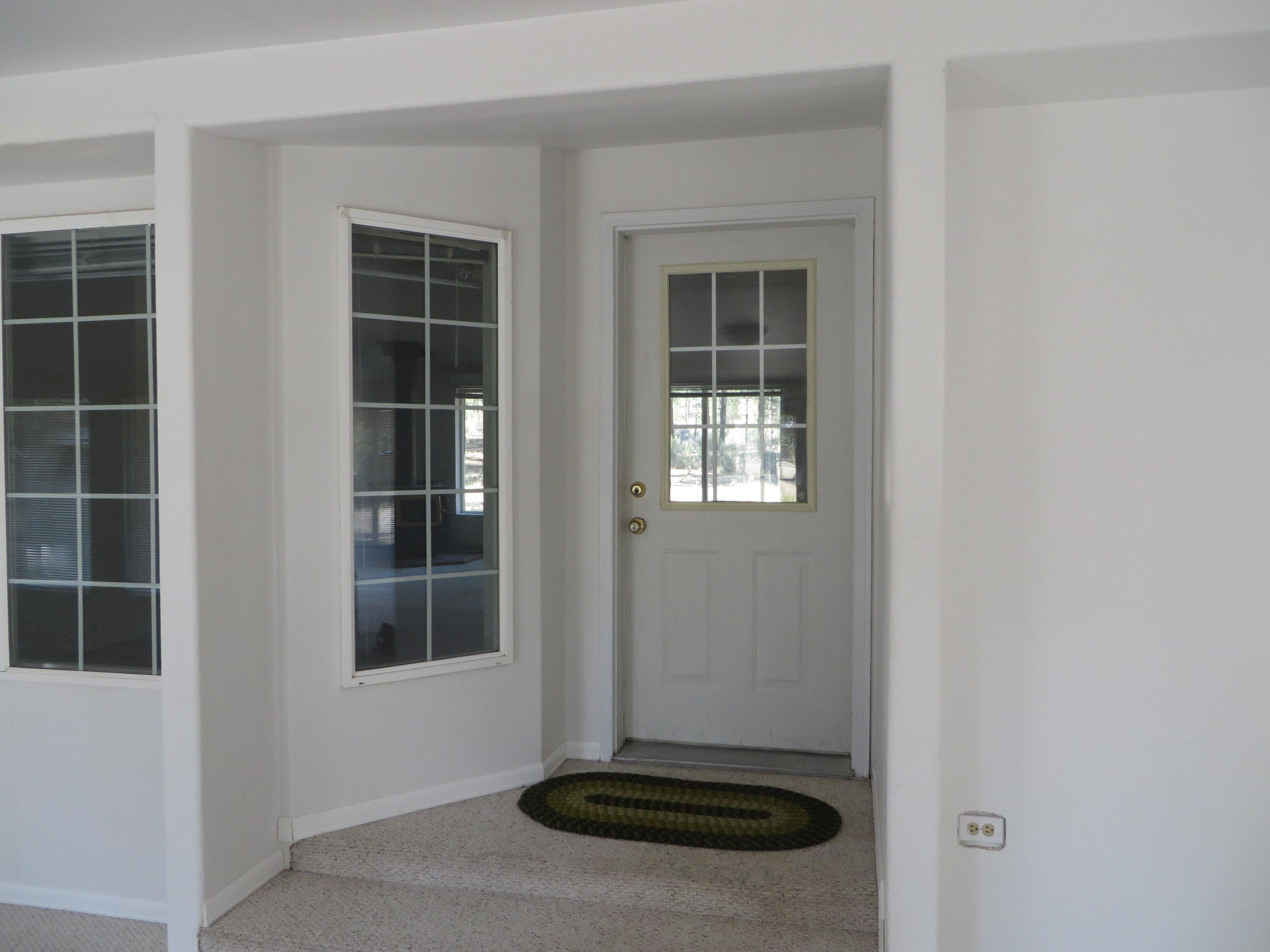 40020 9 Mile Road Chiloquin, OR 97624 - Photo 8 of 54 Entrance into living room from enclosed porch. Another entrance into the laundry room is just down this hall area
