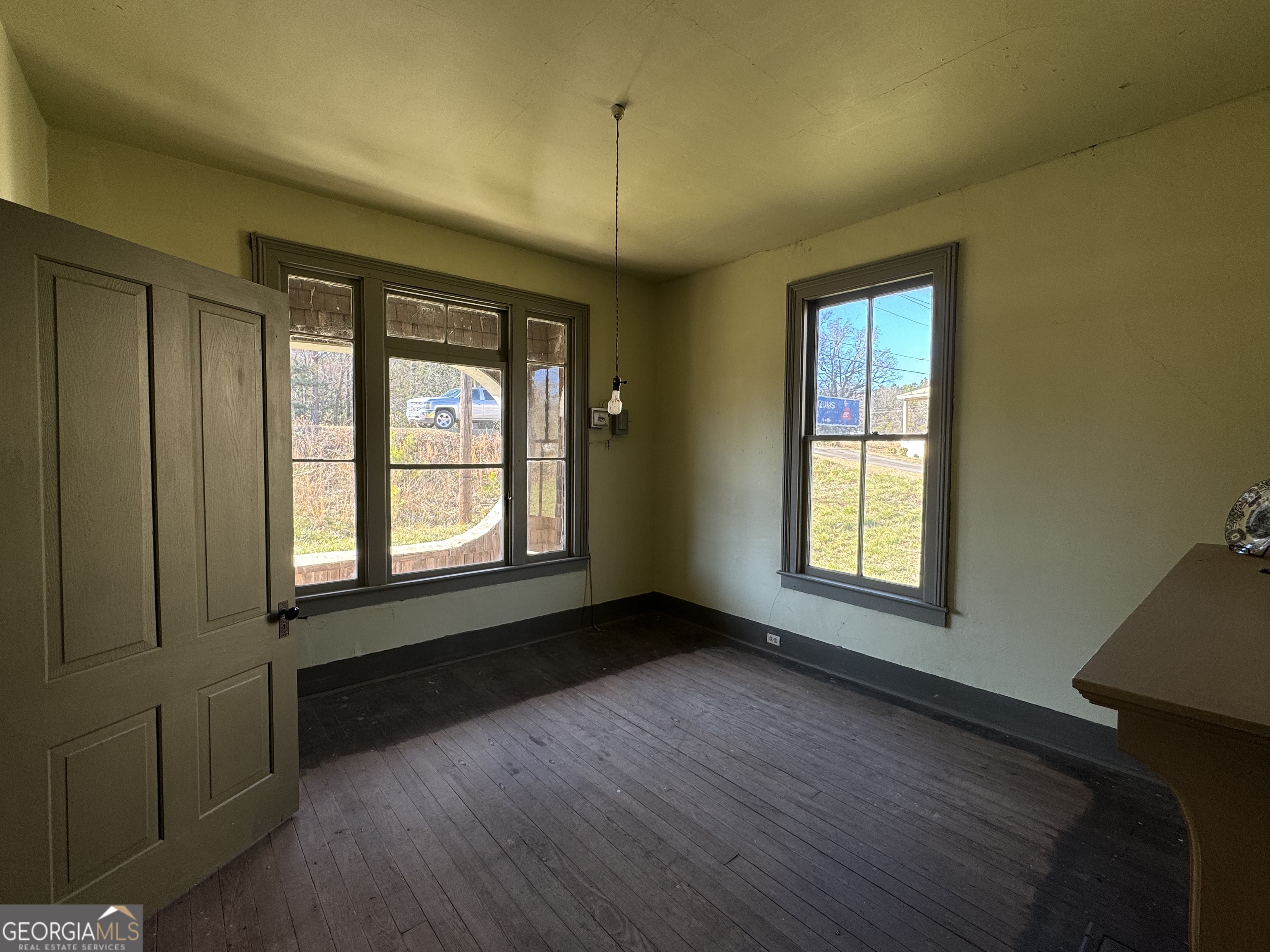 9822 Jones Street Sparta, GA 31087 - Photo 13 of 52 a view of an empty room with a window and wooden floor