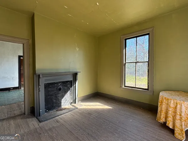 a view of a livingroom with wooden floor and a fireplace