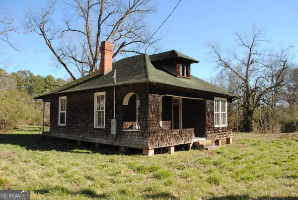 a front view of a house with a yard covered with snow