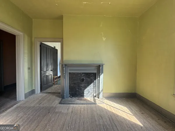 a view of an empty room with a fireplace and a window