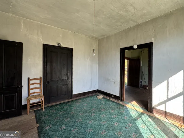 a view of a room with wooden floor and a hallway