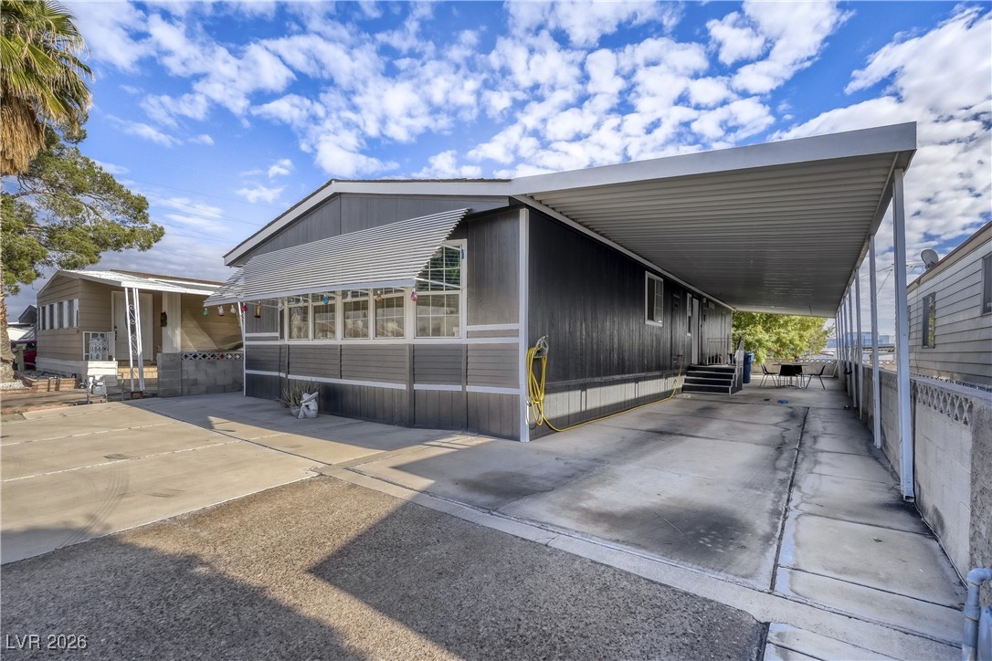 View of side of home with a carport and driveway