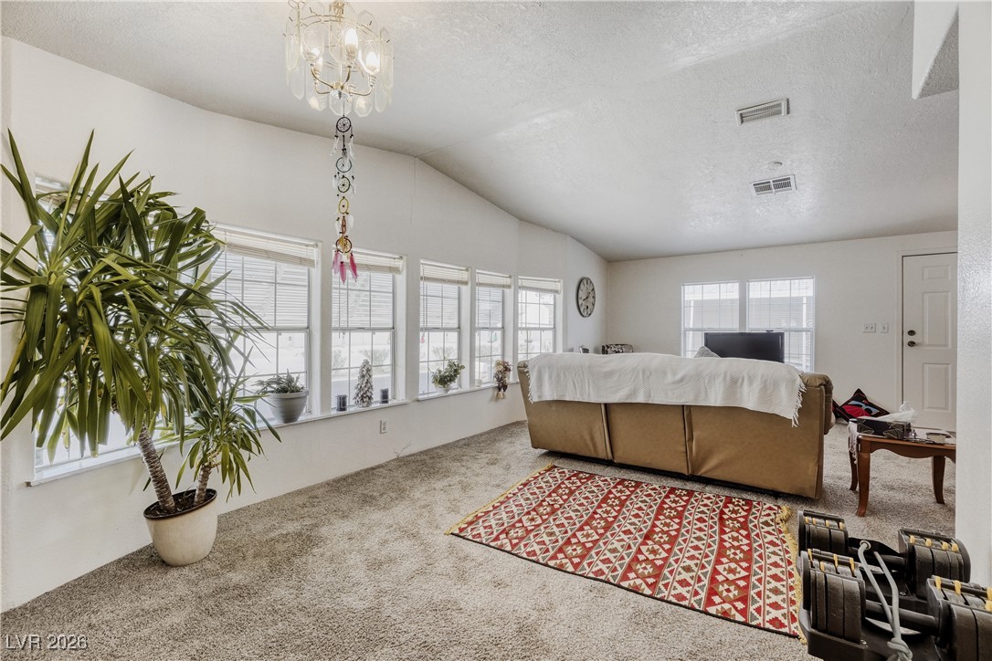 4552 Royal Ridge Avenue Las Vegas, NV 89103 - Photo 4 of 13 Living room with a textured ceiling, carpet, and lofted ceiling
