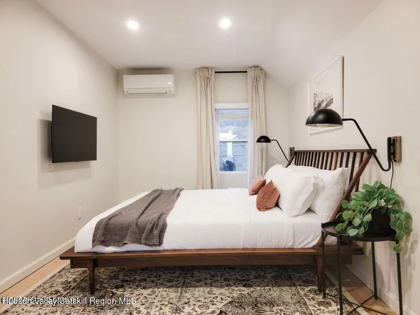 a bedroom with a bed and flat screen tv