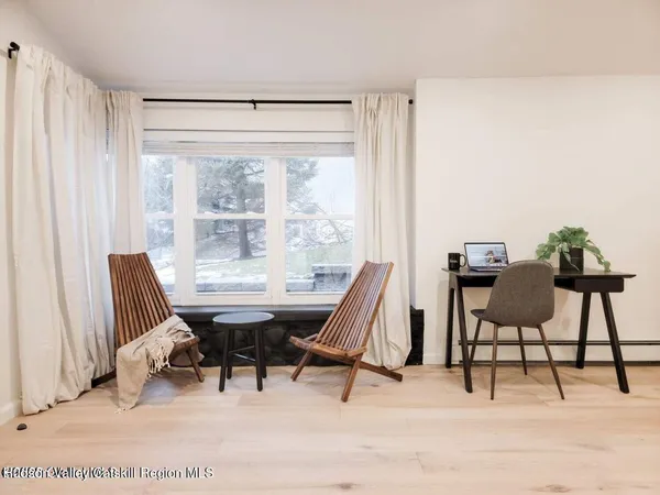 a view of a workspace with furniture and a window
