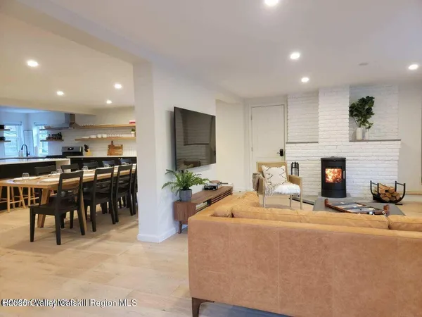 a living room with furniture a fireplace and kitchen view