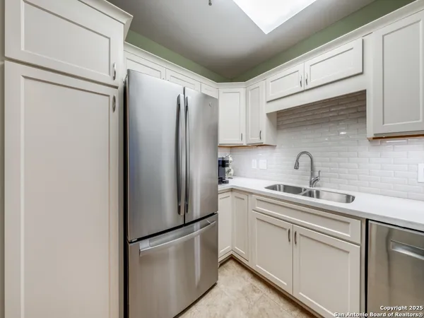a kitchen with stainless steel appliances a refrigerator sink and cabinets