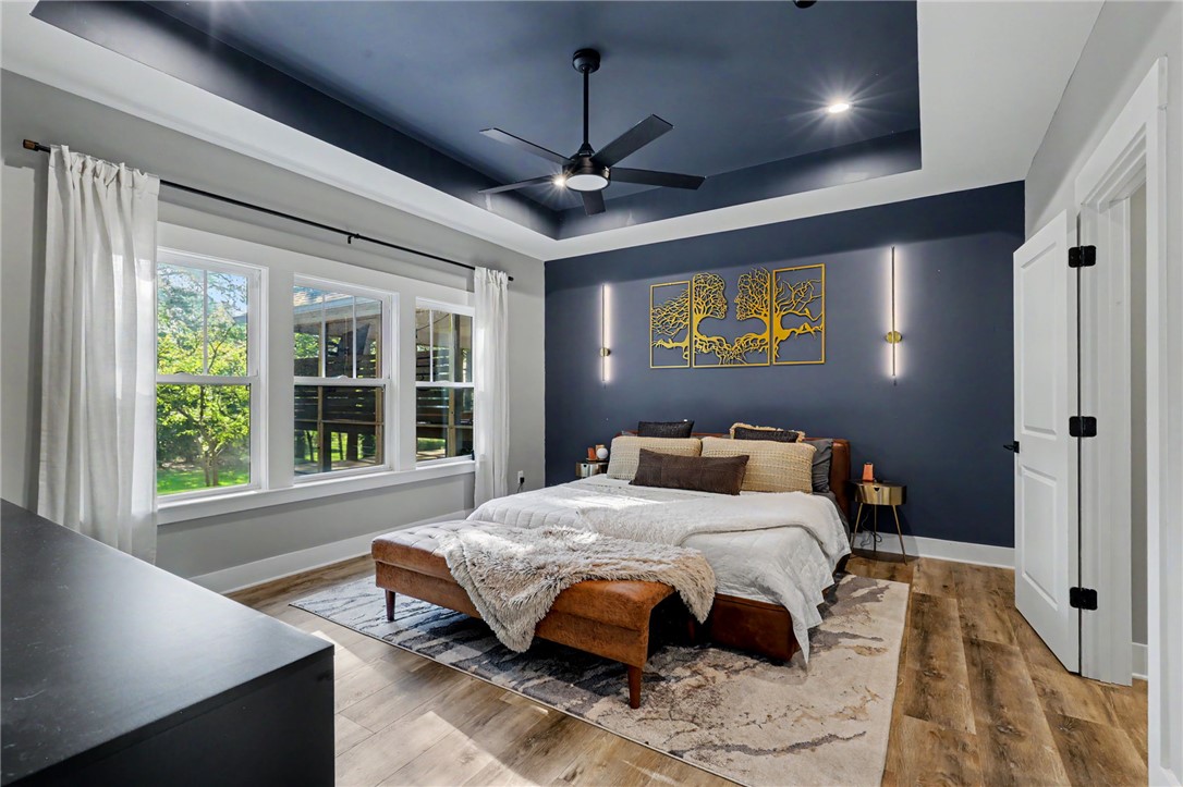701 Coneross Creek Road Seneca, SC 29678 - Photo 13 of 35 A deep tray ceiling and stylish wall-mounted bedside lights add character to the spacious primary bedroom.