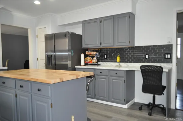 a kitchen with kitchen island granite countertop a sink stove and refrigerator