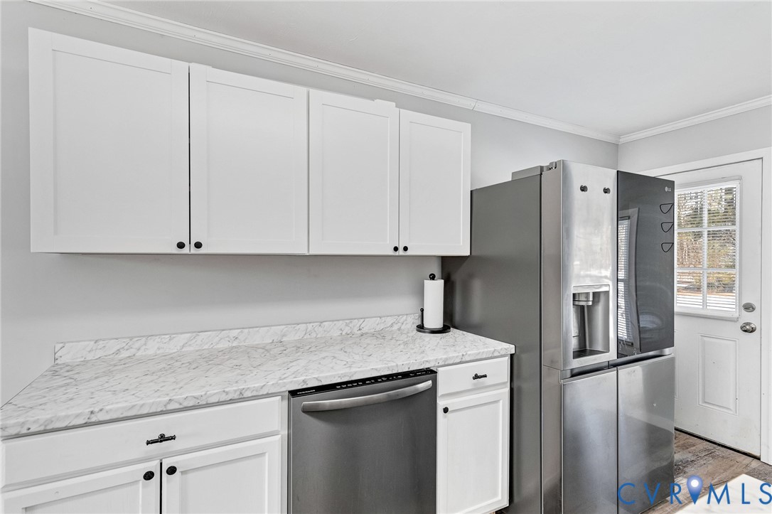 15200 Chieftain Road Disputanta, VA 23842 - Photo 4 of 44 a kitchen with stainless steel appliances granite countertop a refrigerator a sink and white cabinets