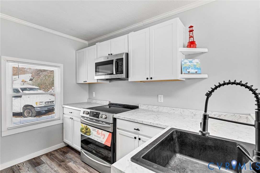 15200 Chieftain Road Disputanta, VA 23842 - Photo 5 of 44 a kitchen with stainless steel appliances granite countertop a sink a stove and a microwave