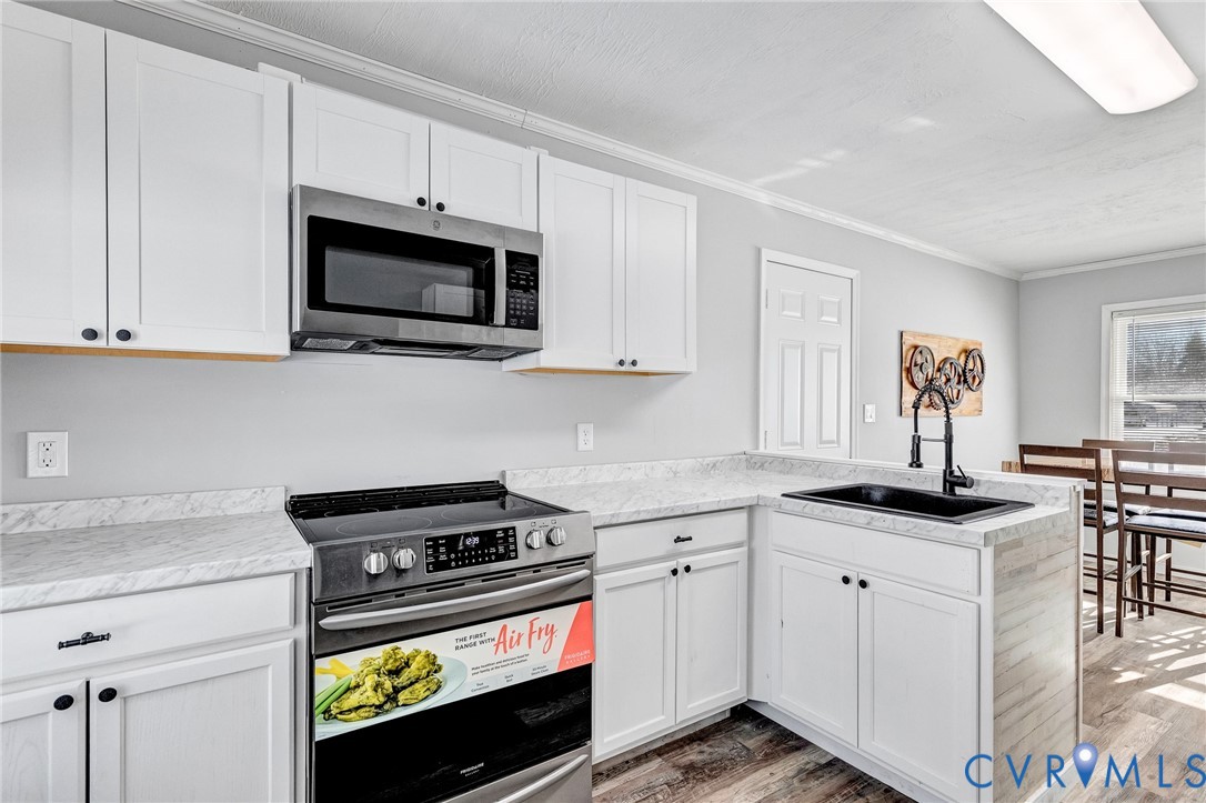 15200 Chieftain Road Disputanta, VA 23842 - Photo 8 of 44 a kitchen with stainless steel appliances white cabinets and a stove a sink