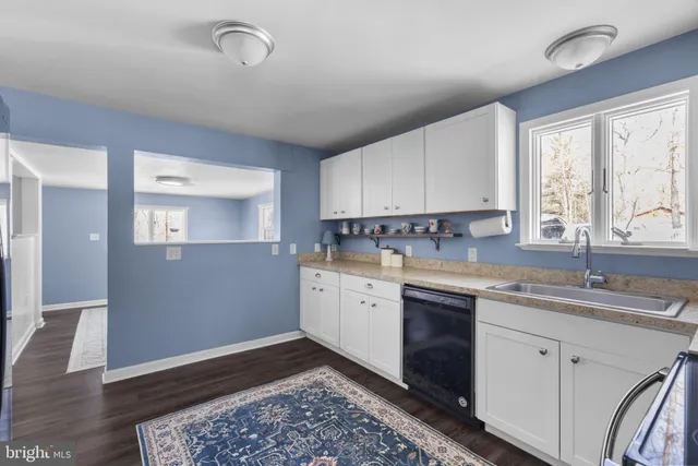 a kitchen with sink cabinets and wooden floor
