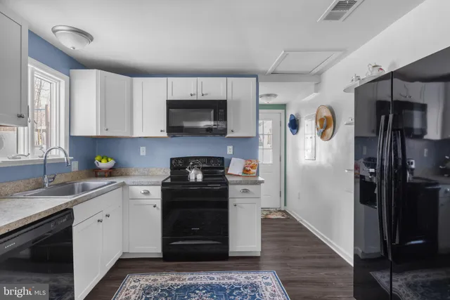 a kitchen with a sink stainless steel appliances and cabinets