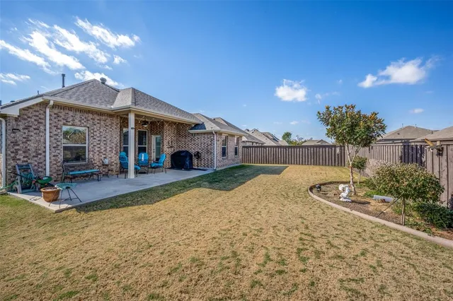 a view of a house with backyard and sitting area