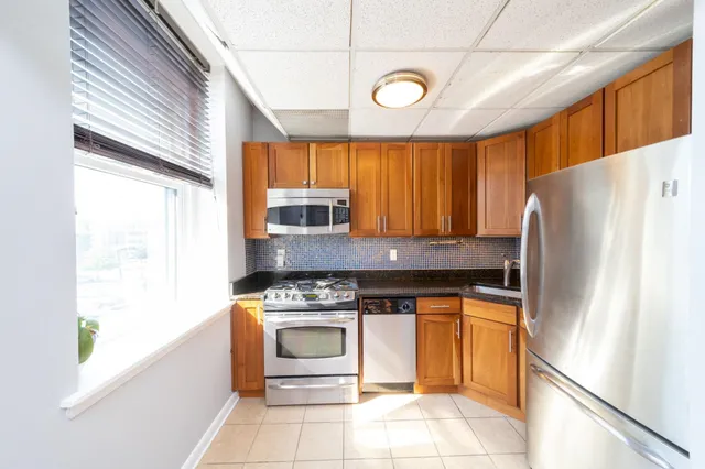 a kitchen with stainless steel appliances granite countertop a refrigerator and a stove