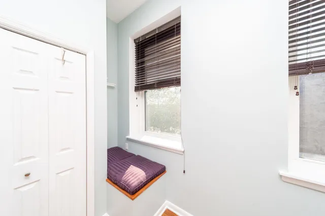 a view of a hallway with a chair and a window