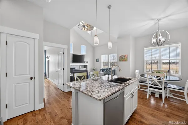 a kitchen with kitchen island granite countertop a stove and a view of living room