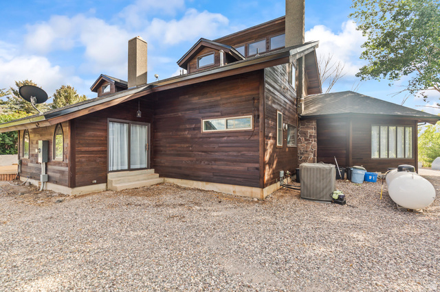 460 Omni Point Road Central Valley, UT 84754 - Photo 74 of 101 Exterior featuring wood siding, a gravel-covered ground surface, and multiple windows