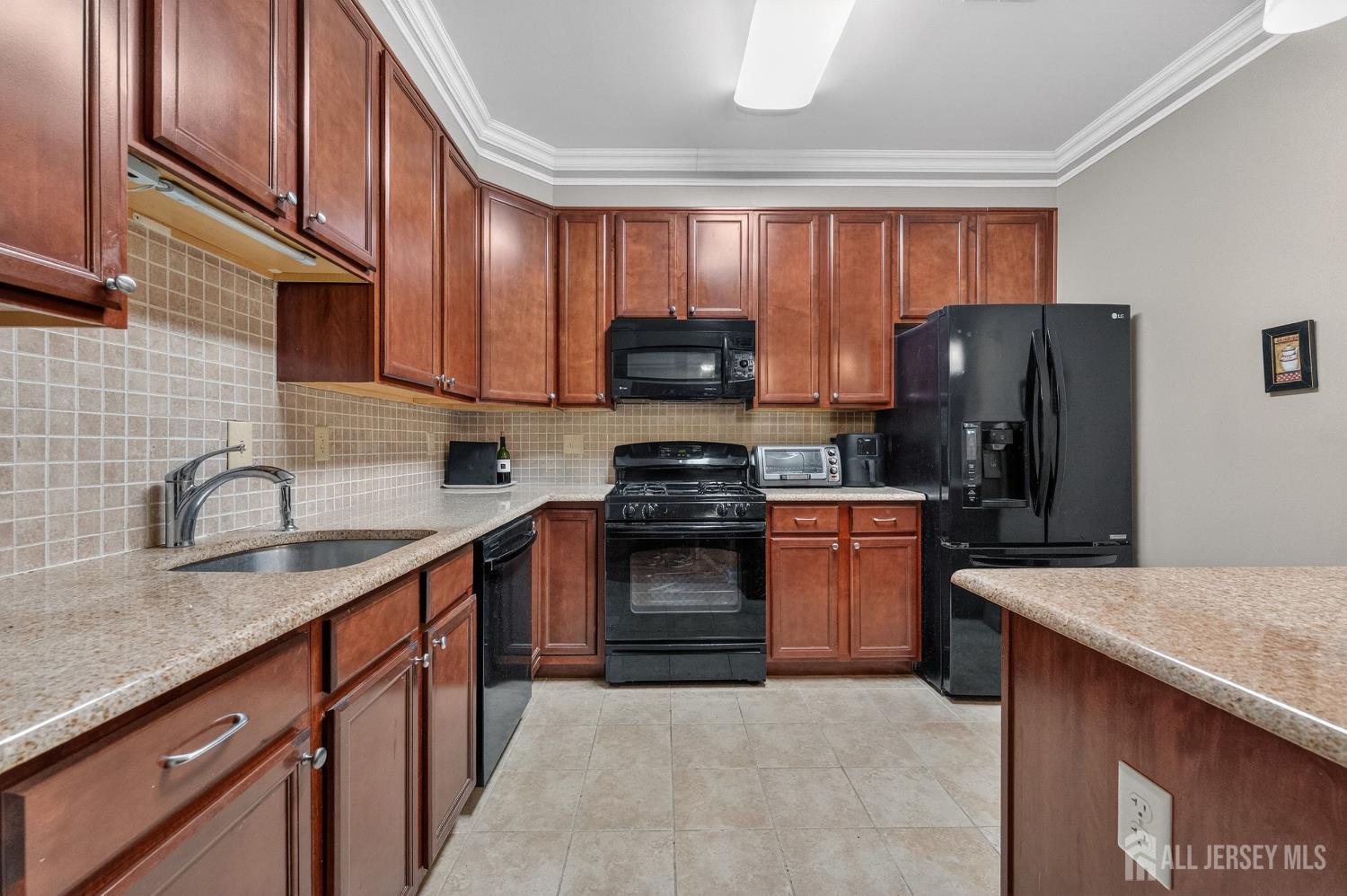 417 Regency Place Woodbridge, NJ 07095 - Photo 10 of 28 a kitchen with granite countertop a stove top oven microwave and refrigerator