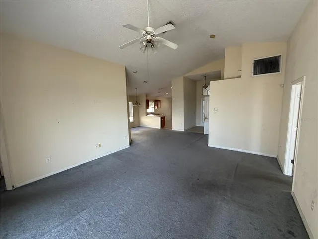 a view of a livingroom with a ceiling fan and a refrigerator