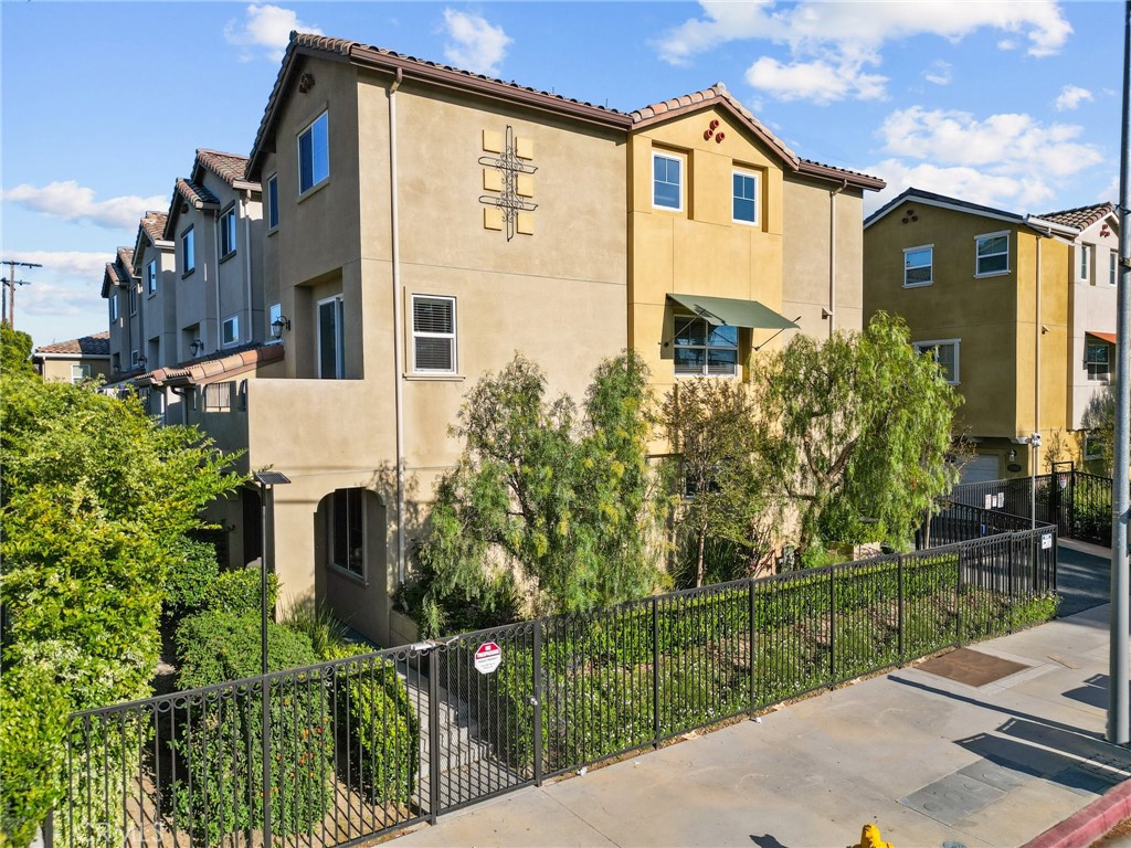 a view of a white house with large windows next to a yard