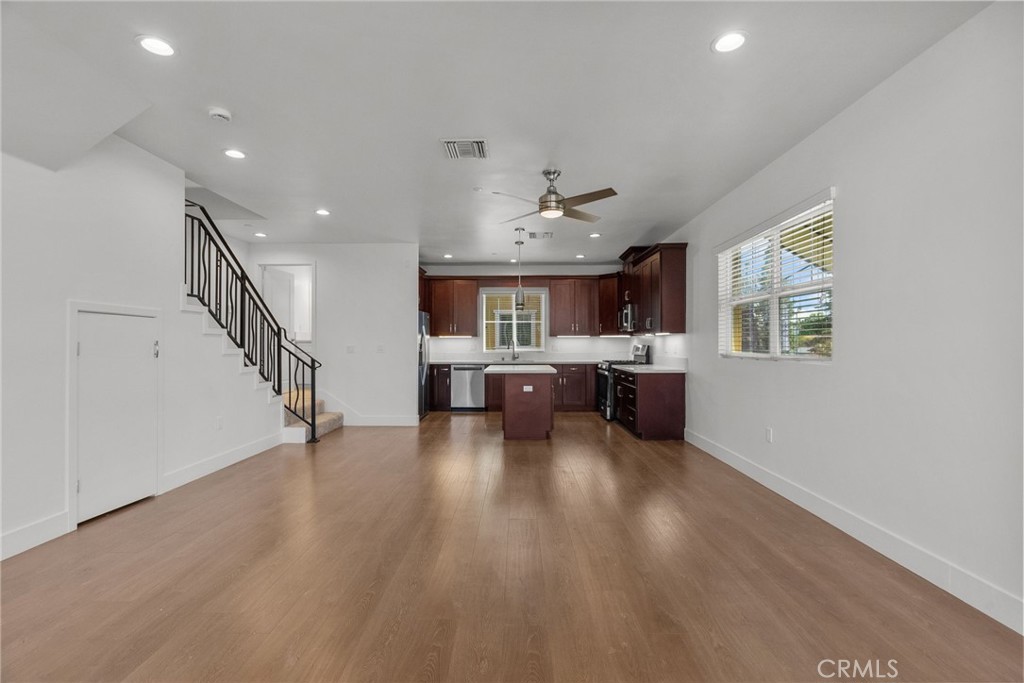 16863 Balboa Boulevard Van Nuys, CA 91406 - Photo 11 of 34 a living room with couches and kitchen view with wooden floor