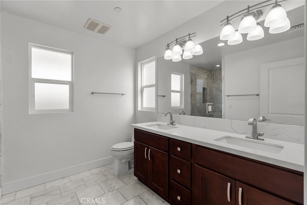 16863 Balboa Boulevard Van Nuys, CA 91406 - Photo 22 of 34 a bathroom with a double vanity sink and a mirror