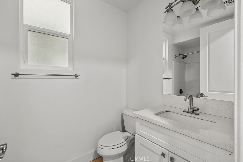 16863 Balboa Boulevard Van Nuys, CA 91406 - Photo 27 of 34 a bathroom with a granite countertop toilet a sink and mirror