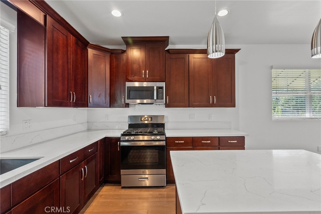 16863 Balboa Boulevard Van Nuys, CA 91406 - Photo 8 of 34 a kitchen with granite countertop a stove a sink and a microwave
