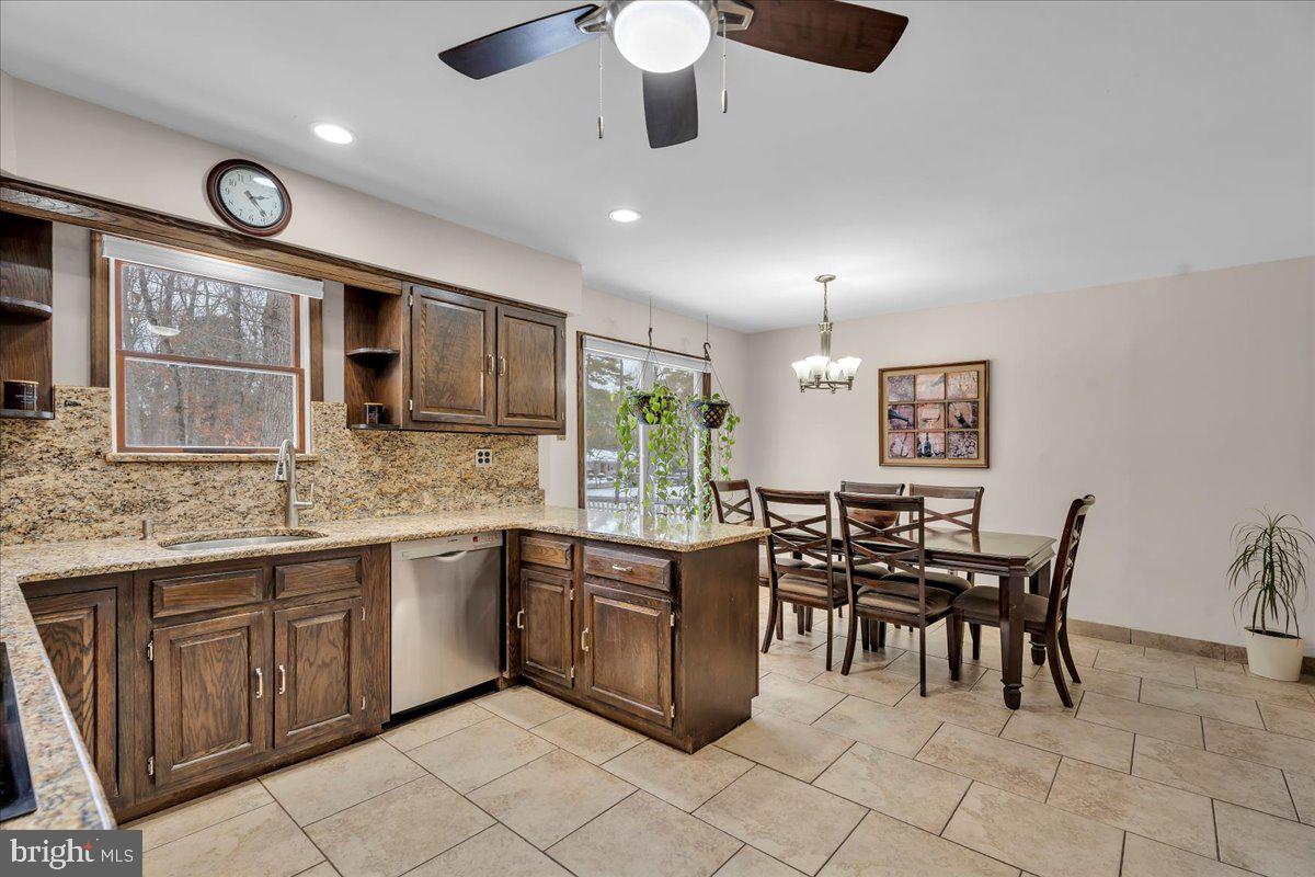 114 Peach Road Marlton, NJ 08053 - Photo 9 of 46 a kitchen with stainless steel appliances granite countertop a stove top oven a sink a dining table and chairs with wooden floor