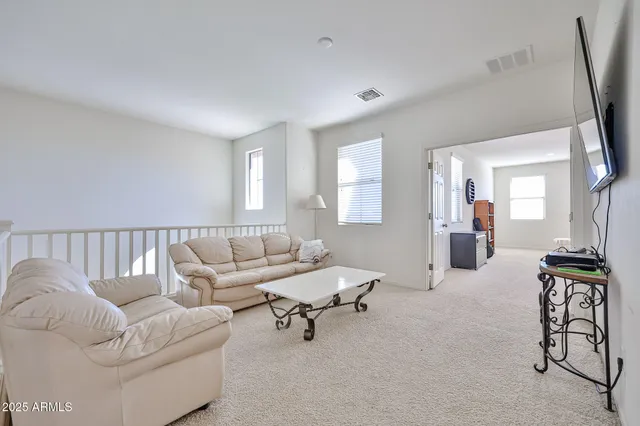 a view of a hallway with wooden floor and windows