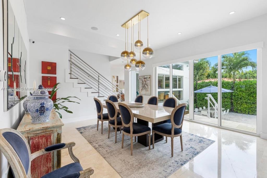 689 Glenridge Road Key Biscayne, FL 33149 - Photo 14 of 48 a dining room with furniture a chandelier and a rug