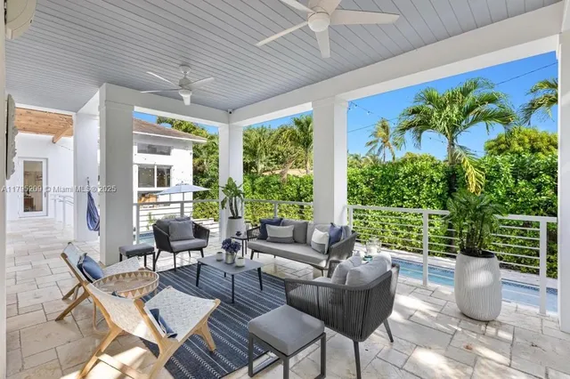 a living room with patio furniture and a potted plant
