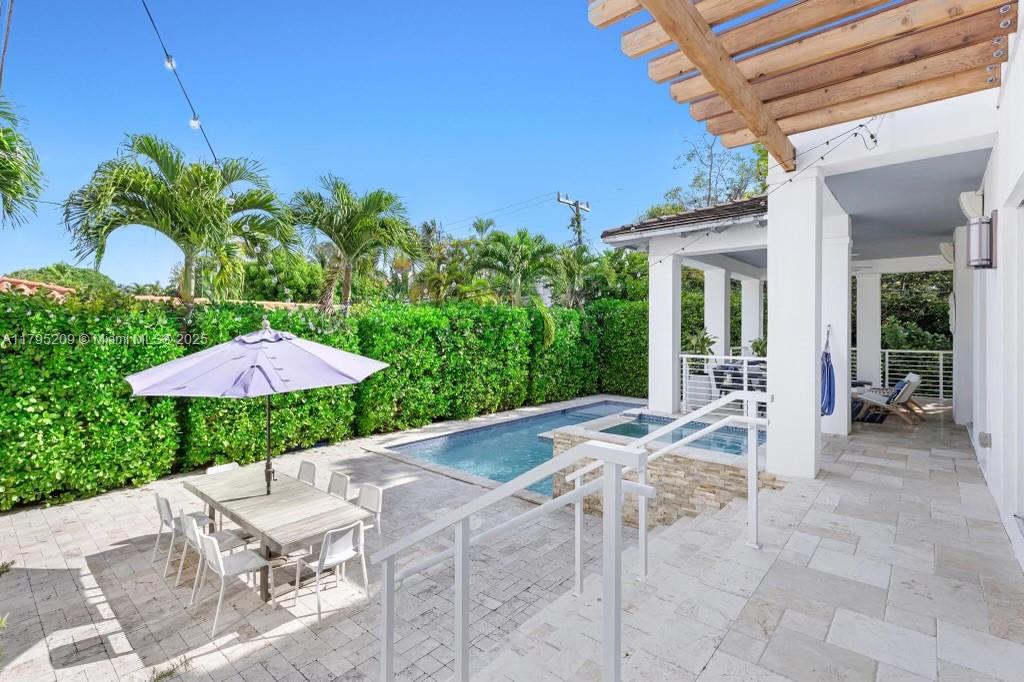 689 Glenridge Road Key Biscayne, FL 33149 - Photo 18 of 48 a view of a patio with a table and chairs under an umbrella
