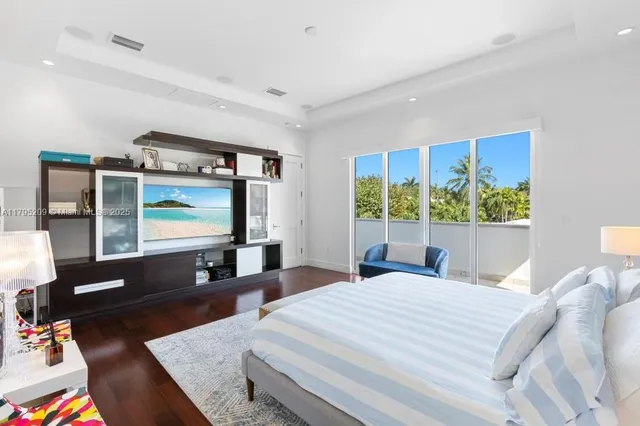 a bedroom with a bed a large window and flat screen tv