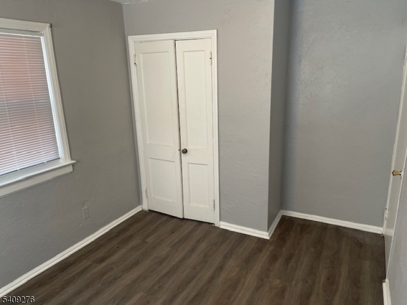 1112 Rivington Street Roselle, NJ 07203 - Photo 12 of 13 a view of an empty room with wooden floor and a window
