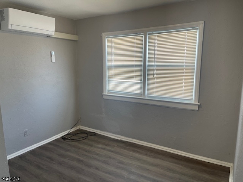 1112 Rivington Street Roselle, NJ 07203 - Photo 8 of 13 a view of an empty room with wooden floor and a window