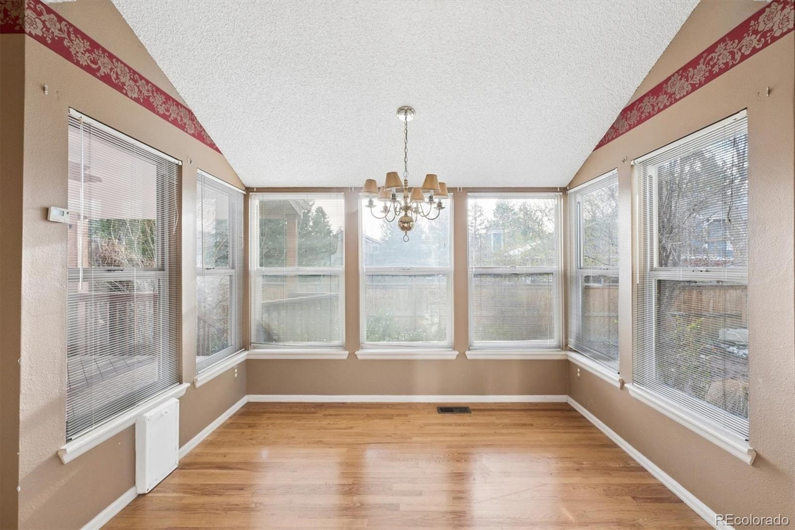 8554 Redstone Street Highlands Ranch, CO 80126 - Photo 12 of 33 a view of an empty room with wooden floor and a window