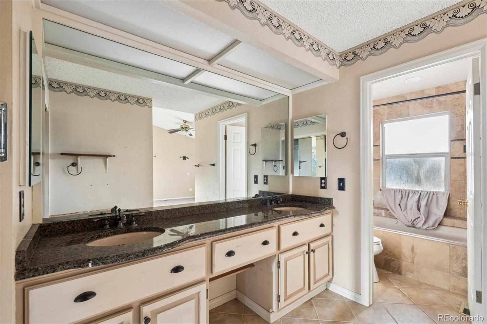 8554 Redstone Street Highlands Ranch, CO 80126 - Photo 22 of 33 a bathroom with a granite countertop sink and a mirror