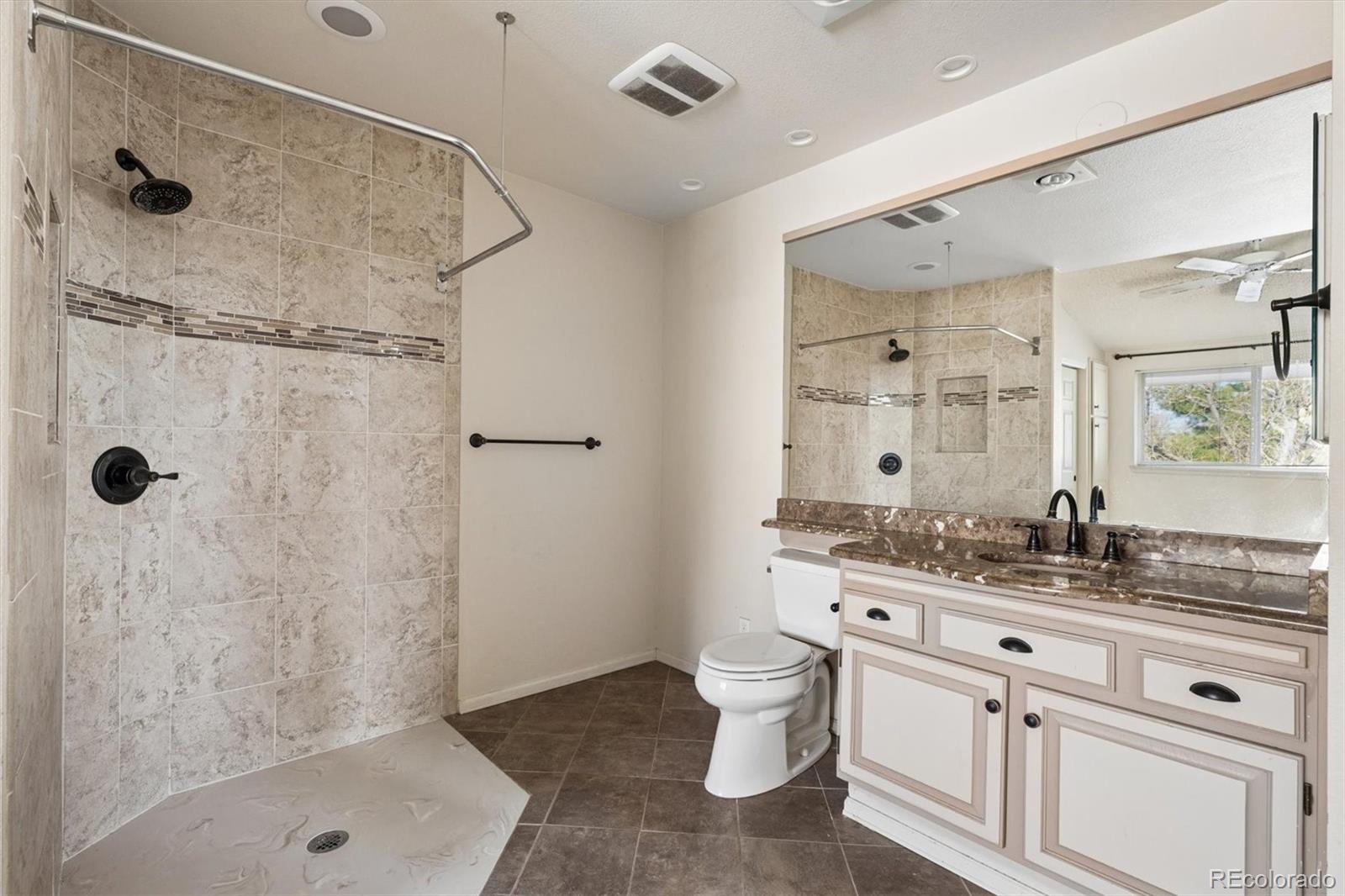 8554 Redstone Street Highlands Ranch, CO 80126 - Photo 24 of 33 a bathroom with a granite countertop sink a toilet and shower