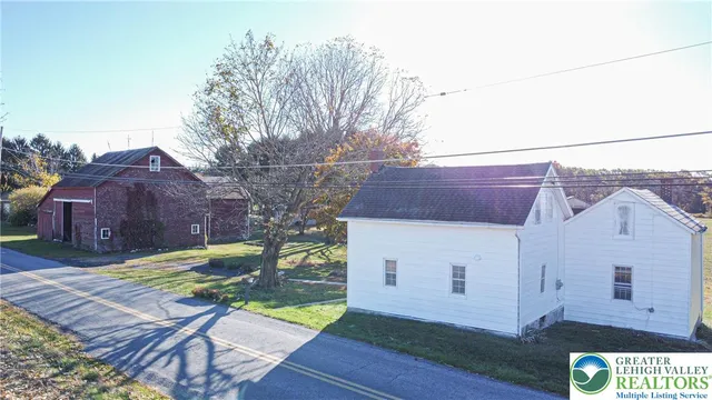 a view of a small house with wooden fence
