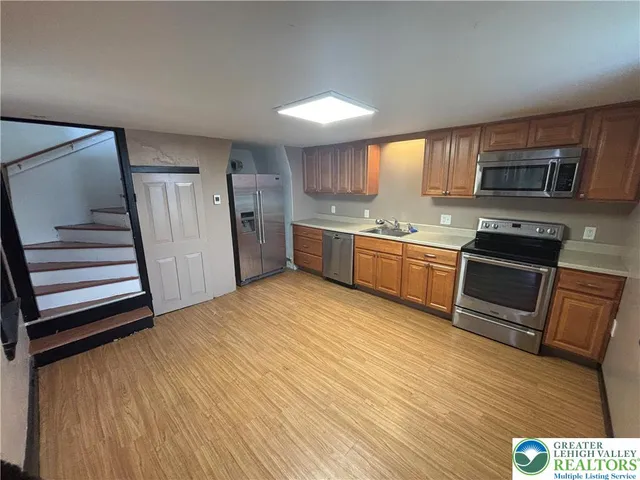 a kitchen with stainless steel appliances granite countertop a stove a sink and a refrigerator