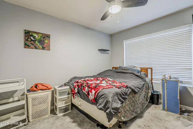 a bedroom with a bed and a painting on the wall