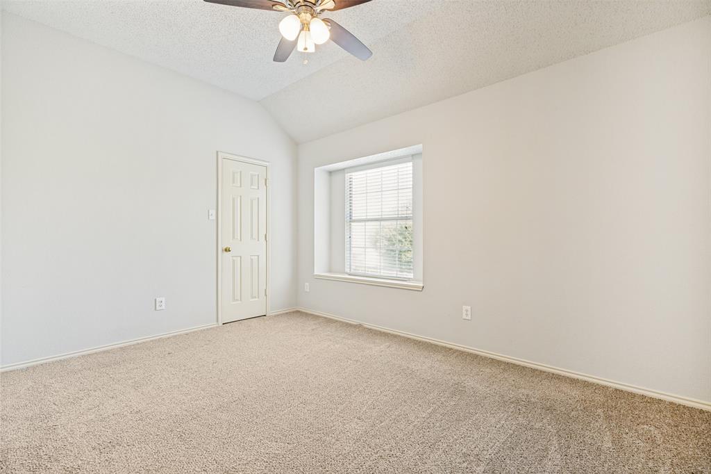 1215 Spring Creek Drive Allen, TX 75002 - Photo 24 of 40 Carpeted interior space featuring a vaulted ceiling and a ceiling fan with light fixture