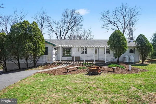 a view of a house with backyard and sitting area