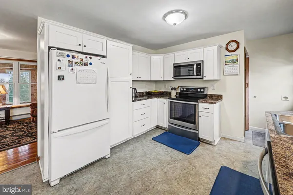 a kitchen with stainless steel appliances granite countertop a refrigerator sink and stove