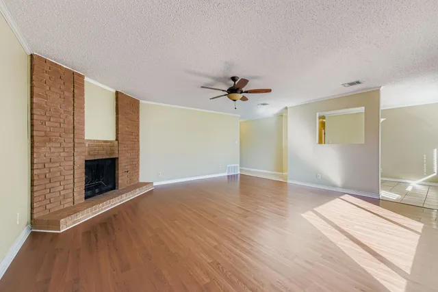 a view of an empty room with a fireplace and a window